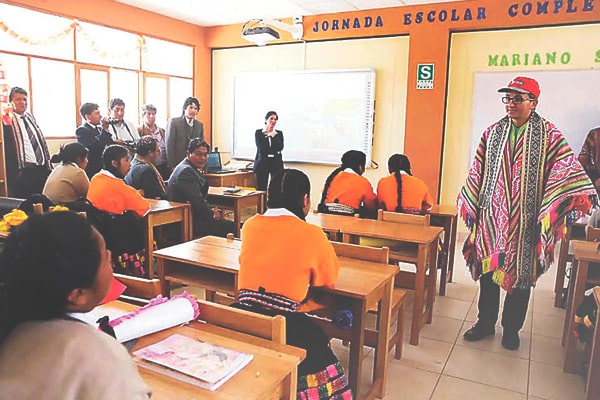 Profesor enseñando a los alumnos tecnología en quechua. Alfabetización digital en quechua.