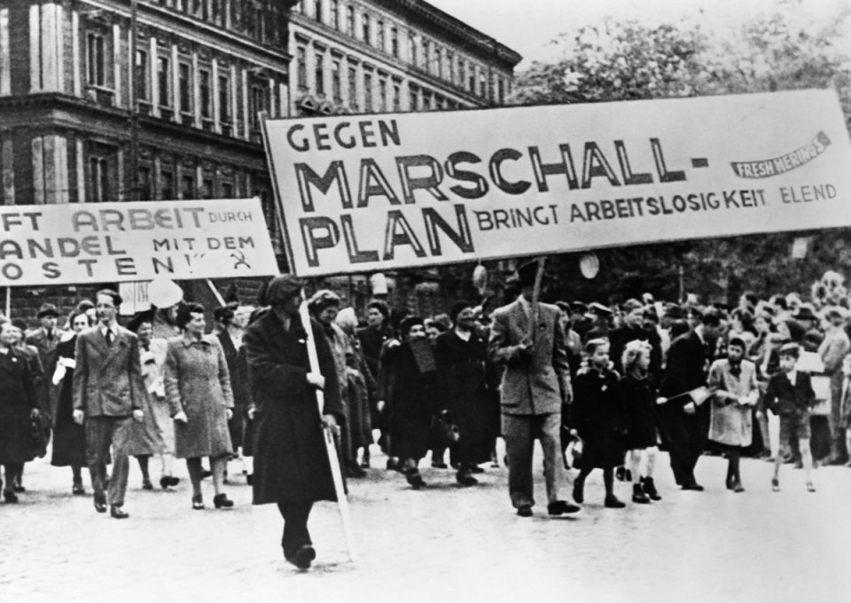 Personas con pancartas. Plan Marshall.